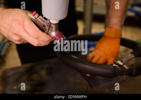 Professionelle Techniken für die Erneuerung von Fahrzeugleder, Nahaufnahme mit detaillierten Arbeiten, die bei der Restaurierung von Lederpolstern für Kraftfahrzeuge verwendet wurden Stockfoto