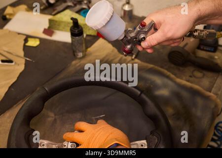 Professionelle Techniken für die Erneuerung von Fahrzeugleder, Nahaufnahme mit detaillierten Arbeiten, die bei der Restaurierung von Lederpolstern für Kraftfahrzeuge verwendet wurden Stockfoto