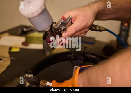 Professionelle Techniken für die Erneuerung von Fahrzeugleder, Nahaufnahme mit detaillierten Arbeiten, die bei der Restaurierung von Lederpolstern für Kraftfahrzeuge verwendet wurden Stockfoto