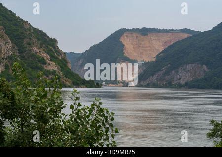 Donauschlucht in der Eisernen Tore-Schlucht, Serbien. Felsige Klippen und grüne Hügel mit ruhiger Wasserlandschaft. Stockfoto