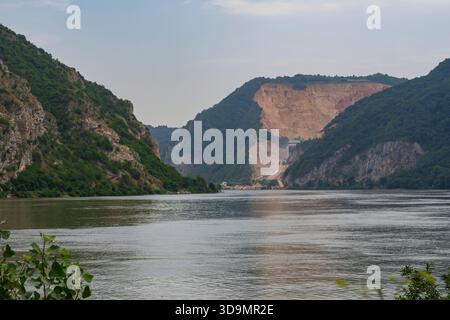 Donauschlucht in der Eisernen Tore-Schlucht, Serbien. Felsige Klippen und grüne Hügel mit ruhiger Wasserlandschaft. Stockfoto