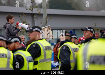 Falkirk, Schottland, Großbritannien. Dezember 2025. Demonstranten versammelten sich vor dem Cladhan Hotel in Falkirk, um sich gegen die Unterbringung von Asylbewerbern an diesem Ort zu wehren. Auf die Demonstration traf ein Gegenprotest, der von "Stand Up to Rassismus" organisiert wurde, dessen Unterstützer sich solidarisch mit den Migranten versammelten. Die Polizei war während der gesamten Zeit stark präsent, um Spannungen zu bewältigen und mögliche Zusammenstöße zwischen den beiden Gruppen zu verhindern. Quelle: Jacob Hughes/Alamy Live News Stockfoto