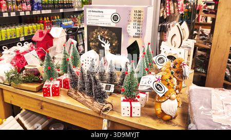 ISERLOHN, DEUTSCHLAND — 06. DEZEMBER 2025: Verschiedene weihnachtsdekorationen, darunter kleine Bäume und Rentiere, im woolworth-Laden ausgestellt Stockfoto