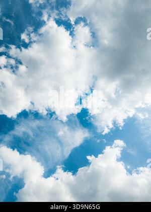Hellblauer Himmel, gefüllt mit weichen weißen Wolken und sanfter atmosphärischer Textur, schafft eine ruhige und belebende natürliche Kulisse, die ideal für Hintergründe ist Stockfoto
