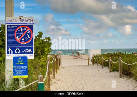 Miami, Florida, USA - 1. Dezember 2024: Sandiger Fußweg nach Miami South Beach mit Holzpfosten und Seilen und Sicherheitsschildern am Strand auf der linken Seite Stockfoto