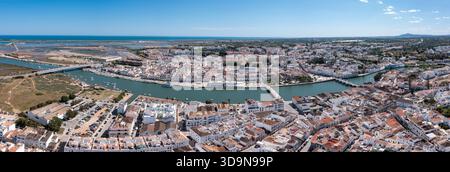 Tavira in der Algarve ist von oben gesehen, mit dem Fluss und weißen Gebäuden mit klarem Himmel. Die Aussicht zeigt die Stadtstruktur und die Umgebung Stockfoto