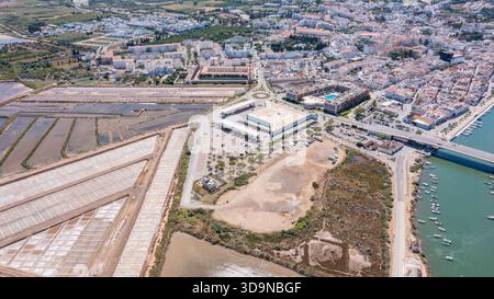 Tavira in der Algarve mit Gebäuden, Salzflächen, einem Fluss und Teilen des Ozeans, die bei sonnigem Wetter in der Ferne sichtbar sind Stockfoto