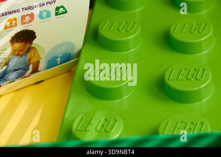 Tyumen, Russland-8. Juli 2025: Ein lebhafter, grüner Baustein Lego wird vor einer hellen und farbenfrohen Kulisse sichtbar. Stockfoto