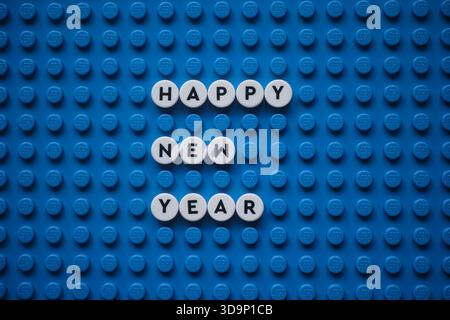 Tambow, Russische Föderation - 06. Dezember 2025 der Satz Happy New Year auf einer blauen Lego-Basisplatte. Die Szene besteht aus Lego Dots. Stockfoto