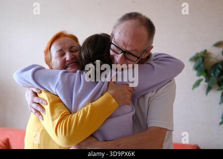 Großeltern umarmen ihre Teenager-Enkelin. Familienwerte, Liebe, Zuhause, Beziehungen, glückliche Familie. Hochwertige Fotos Stockfoto