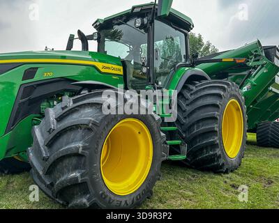 ROSEAU, MN - 23. JUL 2025: Eine schräge Nahaufnahme der großen Reifen eines modernen, leistungsstarken John Deer 8R-Traktoren mit 370 Reihen für Erntegutbetriebe. Stockfoto