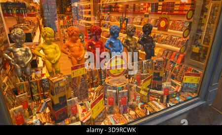 BRÜSSEL, BELGIEN - 26. NOVEMBER 2025 - Manneken Pis Statuen und farbenfrohe Pralinen füllen ein Schaufenster in Brüssel Stockfoto