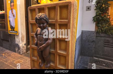 BRÜSSEL, BELGIEN - 26. NOVEMBER 2025 - Manneken Pis Statue auf einer großen Waffelwerbung vor einem Geschäft in Brüssel Stockfoto