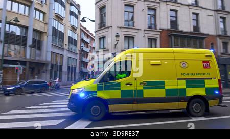 BRÜSSEL, BELGIEN - 26. NOVEMBER 2025 - Ambulanz fährt tagsüber auf einer Stadtstraße in Brüssel, um auf einen Notfall zu reagieren Stockfoto
