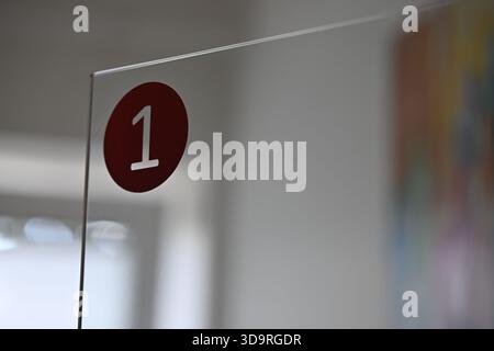 Eine Glastürverkleidung mit einem roten Kreis und der Nummer 1 in einer modernen Büroumgebung. Stockfoto