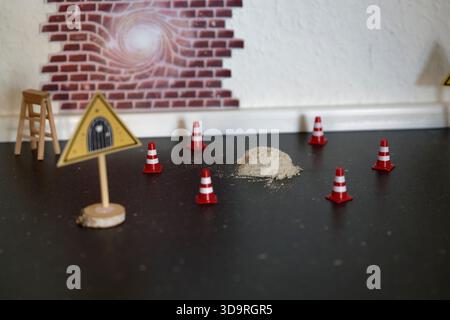 Die verspielte Miniatur-Einrichtung für den kommenden Julenisse in dänemark verfügt über ein dreieckiges Warnschild, rote weiße Verkehrskegel und einen kleinen Sandhaufen, res Stockfoto