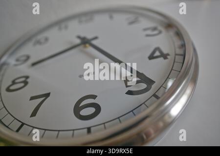 Nahaufnahme einer Quarzuhr, die die Zeit mit großen schwarzen Zahlen und einem silbernen Rahmen zeigt. Stockfoto