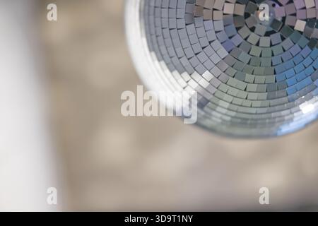 Nahaufnahme einer Discokugel mit reflektierenden Fliesen, verschwommenem Hintergrund. Stockfoto
