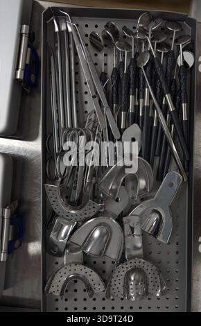 Eine Sammlung verschiedener zahnärztlicher Instrumente in einem Tablett. Zu den Instrumenten gehören Spiegel, Entdecker, Pinzetten und andere Werkzeuge, die in der Zahnmedizin verwendet werden Stockfoto