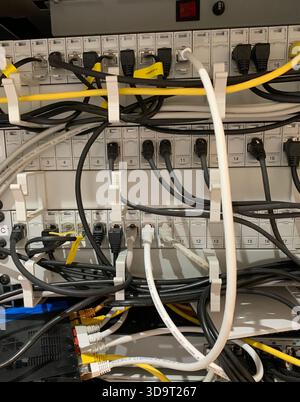 Eine Nahansicht eines Netzwerk-Racks mit verschiedenen, strukturierten Kabeln. Das Rack verfügt über mehrere Anschlüsse und Anschlüsse und zeigt einen Stockfoto