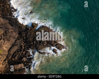 Luftaufnahme der Meereswellen, die gegen Dark Coastal Rocks in Sri Lanka abstürzen Stockfoto