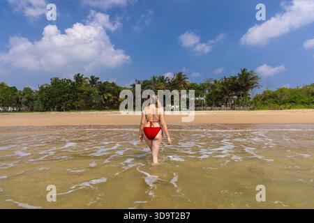 Luftaufnahme einer jungen Frau im roten Badeanzug am Tropical Beach in Talalla, Sri Lanka Stockfoto