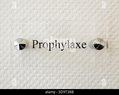 Ein Nahbild eines Schildes mit dem Wort Prophylaxe mit zwei Metallverschlüssen auf einem strukturierten weißen Hintergrund. Stockfoto