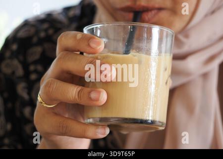 Frau trinkt Eiskaffee in einer Glasschale Stockfoto