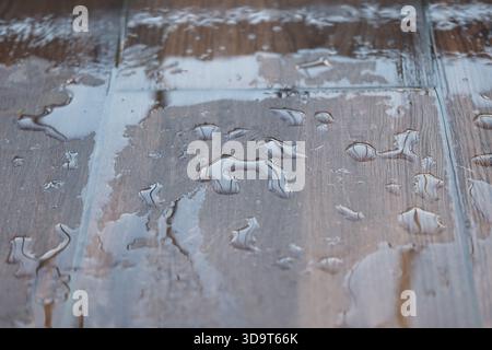 Wasserpfützen auf einem Holzboden nach Regen Stockfoto