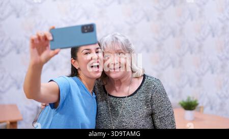 Enkelin und Großmutter freuen sich auf Selfie im Pflegeheim Stockfoto