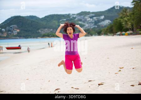 Glückliche Touristen mittleren Alters beim Springen am chaweng Beach in koh samui, Thailand. Stockfoto