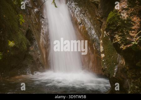 Nahaufnahme eines Wasserfalles mit seidenglattem Wasser, das in einen Pool in Kyprianades Korfu Griechenland spritzt, lange Zeit der Naturbewegung gegen ha ausgesetzt Stockfoto