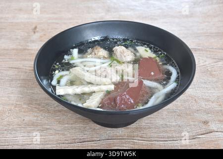 Vietnamesische Reisnudeln oder Pho mit Wurstscheiben und Schweinefleisch sowie Blut in Suppe auf einer Schüssel Stockfoto