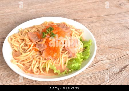 Scharfe gebratene Spaghetti mit Schinkenscheibe, Dressing mit roter koreanischer Sauce, garnelen-Ei auf Teller Stockfoto
