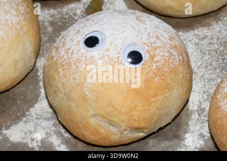 Ein lustiges frisch gebackenes Brötchen mit wackeligen Augen Stockfoto