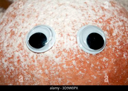 Ein lustiges frisch gebackenes Brötchen mit wackeligen Augen Stockfoto