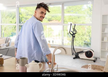 Junger Mann mit Dreadlocks in der Küche Stockfoto