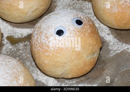 Ein lustiges frisch gebackenes Brötchen mit wackeligen Augen Stockfoto
