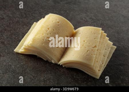 Käsescheiben gefaltet wie ein offenes Buch auf einem Steintisch. Das Konzept der Milchprodukte. Stockfoto