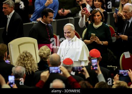 Vatikan, Italien. Dezember 2025. Papst Leo XIV. Kommt in den Saal und begrüßt die Gäste. Papst Leo XIV. Nahm an dem Konzert für die Armen Teil, das im Vatikan mit einem Auftritt des kanadischen Sängers Michael Steven Buble und der Sängerin Serena Autieri im Paul VI. Saal organisiert wurde. (Foto: Marco Iacobucci/SOPA Images/SIPA USA) Credit: SIPA USA/Alamy Live News Stockfoto