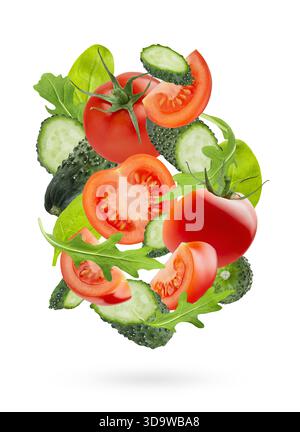 Zutaten für Gemüsesalat - rote Tomaten, grüne Gurken, Spinat, Rucola - Fliege als Swirl Art Komposition, isoliert. Gesund, Vitaminbestandteil Stockfoto