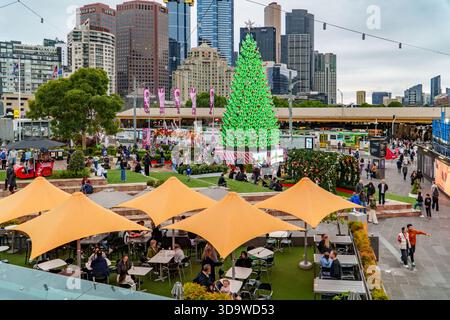 Melbourne, VIC, Australien. Dezember 2025. - Ein Blick aus der Luft fängt einen belebten Stadtplatz in Melbourne mit einem prominenten Weihnachtsbaum im Freien ein Stockfoto