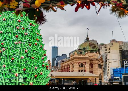 Melbourne, VIC, Australien. Dezember 2025. - Ein beleuchteter, moderner Weihnachtsbaum steht vor der historischen Flinders Street Stati Stockfoto