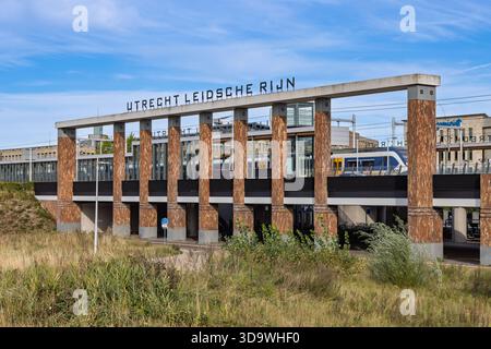 Der Bahnhof Utrecht Leidsche Rijn verfügt über markante Holzsäulen, modernes Design und einen vorbeifahrenden Zug unter blauem Himmel. Utrecht, Niederlande. 2 Stockfoto