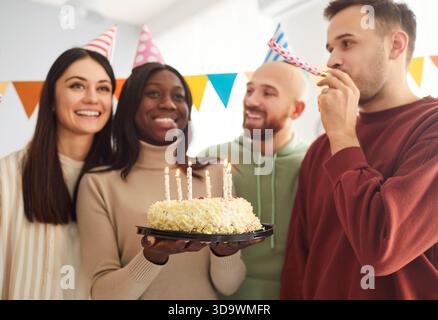 Gruppe fröhlicher optimistischer Freunde, die Spaß auf der Geburtstagsfeier haben Stockfoto