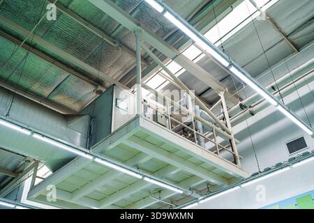 Industriedecke mit Lüftungssystem mit Kanälen, HLK-Einheit, Isolierung und Metallrohren im Innenraum der Fabrik Stockfoto