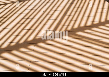 Diagonales Schattenmuster auf Holzboden von Lattendach Stockfoto