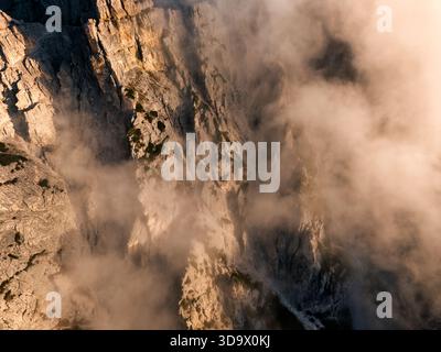 Aus der Vogelperspektive auf die dramatische zerklüftete Bergklippe mit dichtem Sonnenaufgang in Trecime, Dolomiten, Italien Stockfoto