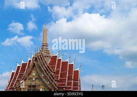 Auf dem Dach des thailändischen Tempels mit fünfstufigem Turm unter einem hellblauen Himmel, der buddhistische Architektur und das südostasiatische Erbe hervorhebt. Stockfoto