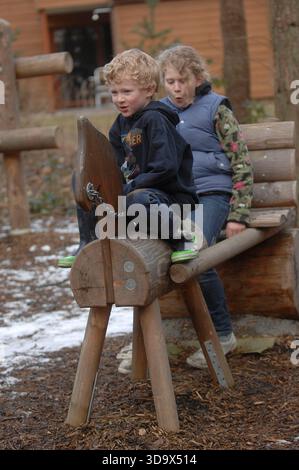 Eine Familie im Center Parcs, Elveden Forest, in Suffolk in der Nähe von Thetford. Es wurde 1989 auf einem 400 Hektar großen Pinienwald eröffnet und bietet Unterkünfte zur Selbstverpflegung für bis zu 8 Gäste, darunter auch barrierefreie, haustierfreundliche und Baumhäuser. Das subtropische Schwimmparadies hat Pools, Rutschen und einen faulen Fluss. Zu den Aktivitäten gehören Radfahren, Bogenschießen, Töpferei, Wassersport auf dem See, Hochseile, Spa-Behandlungen, Minigolf und Indoor-Klettern. Zu den Einrichtungen gehören Restaurants, Cafés, ein Geschäft, Aqua Sana Spa und Kinderclubs. Kurzurlaube und einwöchige Aufenthalte sind das ganze Jahr über verfügbar. Stockfoto